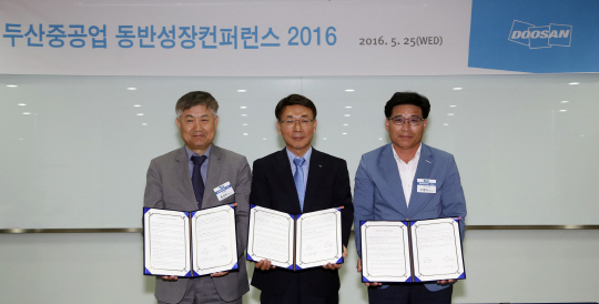 지난 5월 열린 ‘두산중공업 동반성장컨퍼런스 2016’에서 김명우(가운데) 두산중공업 사장이 협력사 대표와 공정거래 및 동반성장 협약을 체결하고 있다.