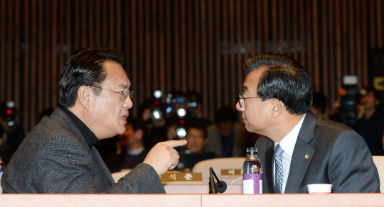 새누리당 이정현(오른쪽) 대표와 정진석 원내대표가 25일 오전 국회 예결위원회 회의장에서 열린 의원총회에 앞서 심각한 표정으로 이야기를 나누고 있다.