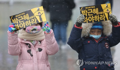 (서울=연합뉴스) 올 겨울 첫 눈이 내린 26일 박근혜 대통령 하야 촉구 촛불집회가 예정된 광화문에서 어린이들이 피켓을 들고 있다.
