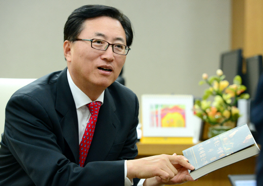 최중경 한국공인회계사회 회장이 ‘회계는 어떻게 역사를 지배해왔는가’라는 책을 보여주며 회계의 중요성을 설명하고 있다.