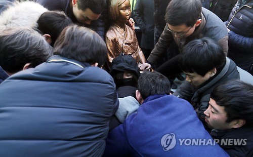 (부산=연합뉴스) 부산 시민단체가 28일 부산 일본영사관 앞에서 기습적으로 소녀상을 설치한 가운데 구청 직원들이 소녀상에서 연좌농성을 벌이던 시민을 강제로 끄집어내고 있다.