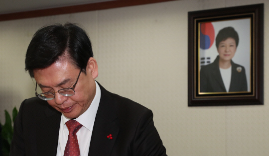 정우택 새누리당 원내대표가 2일 오전 여의도 당사에서 열린 주요당직자회의에서 고개를 숙인 채 심각한 표정을 짓고 있다. 정 원내대표 어깨 뒤로 박근혜 대통령의 사진이 보인다.