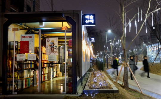 2일 밤 시민들이 빛 조명 장식으로 환하게 불을 밝힌 ‘경의선 책거리’를 지나가고 있다. 마포구 홍대 인근에 있는 경의선 책거리는 지난해 10월 말 개장한 지 두 달 만에 시민들의 힐링문화공간으로 사랑받고 있다.