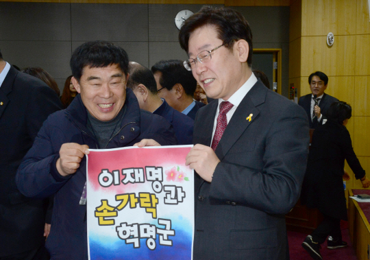 이재명(오른쪽) 성남시장이 3일 오전 국회에서 열린 토론회장에서 SNS 지지세력인 ‘손가락 혁명군’ 회원으로부터 격려 문자가 적힌 포스터를 받고 있다.  신창섭 기자 bluesky@