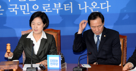6일 오전 국회에서 열린 더불어민주당 최고위원회의에서 추미애(왼쪽) 대표가 개회선언을 하는 동안 우상호 원내대표가 머리를 만지고 있다.