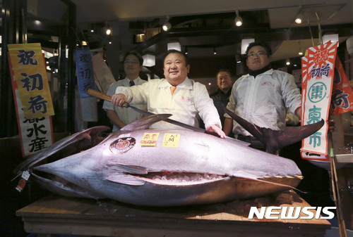 일본 최대 수산물시장인 도쿄 쓰키지(築地)시장에서 5일 오전 열린 새해 첫 참치 경매에서 참치 한 마리를 7420만에(약 7억 6000만원) 낙찰한 기무라 기요시(木村淸·가운데)가 해당 참치 앞에서 포즈를 취하고 있다.