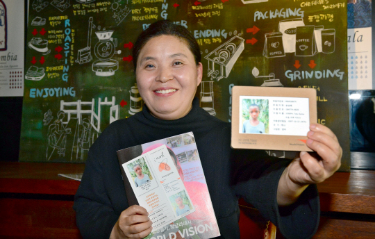 시각장애인 송삼례 씨가 10일 서울 관악구의 한 카페에서 기쁜 표정으로 자신이 후원하는 아동의 사진을 들어 보이고 있다.  김동훈 기자 dhk@