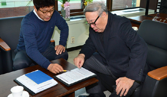 김응용 회장이 신현석 이사의 설명을 들으면서 결재 서류를 꼼꼼하게 살피고 있다.