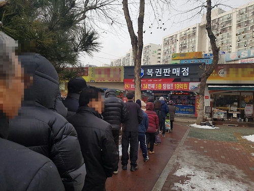 21일 이른바 ‘당첨 명당’으로 소문난 서울 노원구 한 복권판매점에 80여명의 시민들이 복권을 사기 위해 기다리고 있다.
