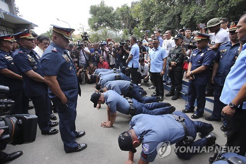 한국인 관광객을 상대로 강도질한 혐의를 받는 필리핀 경찰관들이 경찰청장 지시로 팔굽혀펴기하는 모습.[EPA=연합뉴스]