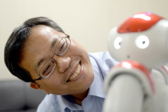 장병탁 서울대 컴퓨터공학부 교수는 “인공지능(AI)을 탑재한 로봇을 교육하다 보면 ‘정말 나를 알아 보는 건가’ 하는 느낌을 받을 때가 있다”며 “기술자로서 휴먼 레벨 AI를 만들고 싶은 꿈이 있지만, 철학적으로까지 가능할지는 모르겠다”고 말했다. 장 교수가 지난 20일 서울대 컴퓨터신기술공동연구소 연구실에서 휴머노이드 ‘나오’(NAO)를 바라보며 밝게 웃고 있다.  김선규 기자 ufokim@