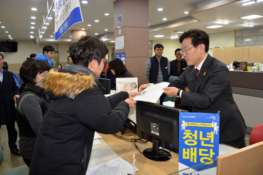 이재명(오른쪽) 경기 성남시장이 지난해 12월 성남시 하대원동 주민센터에서 수혜자에게 청년배당 사업을 설명하고 있다.