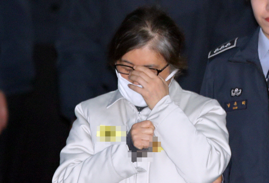 ‘박근혜정부 비선 실세’ 최순실 씨가 13일 오전 서울 서초구 서울중앙지법에서 열린 속행 공판에 출석하기 위해 호송차에서 내려 법정으로 걸어가면서 얼굴을 가리고 있다. 최 씨는 지난 10일 헌법재판소의 대통령 탄핵 선고 소식을 전해 듣고 통곡했던 것으로 전해졌다.