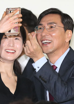 안희정(오른쪽) 충남지사가 15일 서울대 글로벌사회공헌단에서 강연을 마친 뒤 손가락 하트 모양을 만들며 학생과 ‘인증샷’을 찍고 있다.  연합뉴스