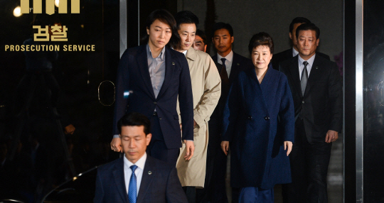 박근혜 전 대통령이 22일 오전 피의자 신분으로 21시간 30여 분간의 검찰 조사를 받고 난 뒤 변호인단 및 수행원들과 함께 서초동 서울중앙지검 청사 정문을 나서고 있다.