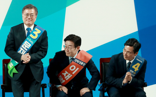 더불어민주당 대선 주자인 문재인(왼쪽부터) 전 대표, 이재명 성남시장, 안희정 충남지사가 27일 광주여대 유니버시아드 체육관에서 열린 순회 경선에서 호남권역 투표 결과가 발표되자 자리에서 일어나고 있다.  연합뉴스