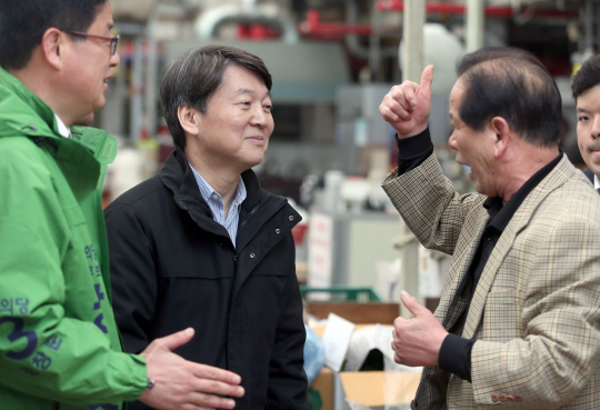 안철수(가운데) 전 국민의당 대표가 27일 경남 양산시 남부시장을 방문해 한 시민으로부터 격려의 말을 듣고 있다.  연합뉴스