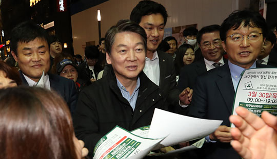 안철수(가운데) 전 국민의당 대표가 29일 대구 동성로를 찾아 시민들에게 30일 열리는 경선 현장투표장 안내 유인물을 나눠주고 있다.  연합뉴스