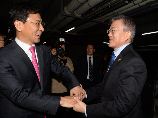 문재인(오른쪽) 더불어민주당 대선 후보가 7일 충남도청을 방문해 당내 경선 경쟁자였던 안희정 충남지사의 손을 붙잡고 인사를 나누고 있다.