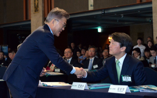 문재인(왼쪽) 더불어민주당 대선 후보와 안철수 국민의당 대선 후보가 12일 오전 서울 중구 소공동 롯데호텔에서 ‘대한민국, 어떻게 바꿀 것인가’라는 주제로 열린 한국포럼에서 악수하고 있다. 웃는 얼굴로 악수를 청한 문 후보와 다소 굳은 얼굴로 손을 맞잡은 안 후보의 표정이 대조를 이루면서 지지율 1, 2위 후보 간의 긴장감이 느껴진다.