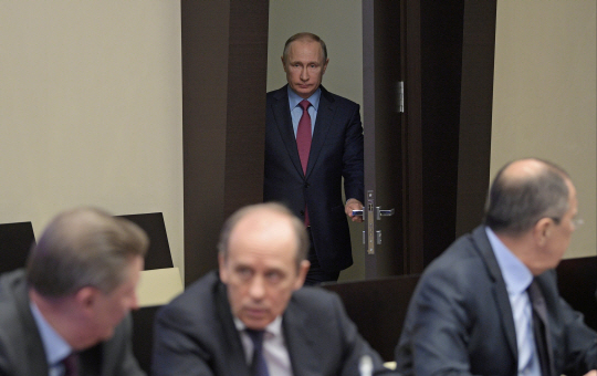 블라디미르 푸틴 러시아 대통령이 13일 모스크바 외곽 노보 오가료보 관저에서 열린 안보위원회 회의에 참석하기 위해 문을 열고 들어서고 있다. 푸틴 대통령은 화학무기를 사용한 시리아 정부를 감싸고 미국의 시리아 정부군 기지 폭격을 비난하는 등 미국과 각을 세우고 있다.  AP연합뉴스