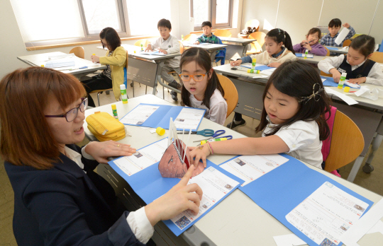 13일 서울 서대문구 독립문공원길 구립 이진아기념도서관에서 열린 ‘우리마을 도서관 잔치’의 참가 어린이들이 강사의 지도 아래 팝업북 만들기를 하고 있다.