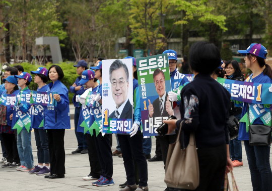 19대 대선 공식선거운동이 시작된 17일 오전 서울 고속버스터미널 앞에서 문재인 더불어민주당 후보 선거운동원들이 문 후보 포스터 사진을 들고 지나가는 시민들에게 지지를 호소하고 있다.
