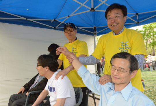 20일 서울 은평구 평화공원에서 열린 ‘은평봄봄축제’ 현장에서 김우영(오른쪽) 은평구청장이 장애인단체 관계자의 어깨를 주물러주고 있다. 김호웅 기자 diverkim@