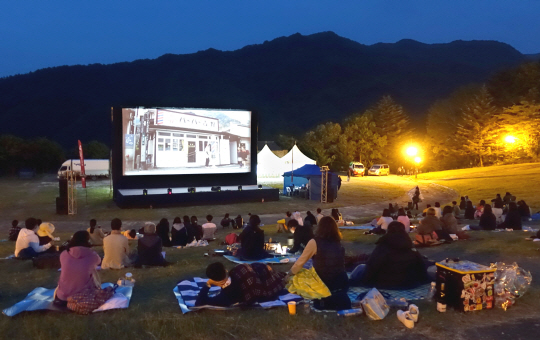 지난해 열린 제4회 무주산골영화제 참가자들이 덕유산 국립공원에 마련된 숲속극장에서 영화를 관람하고 있다.  자료사진