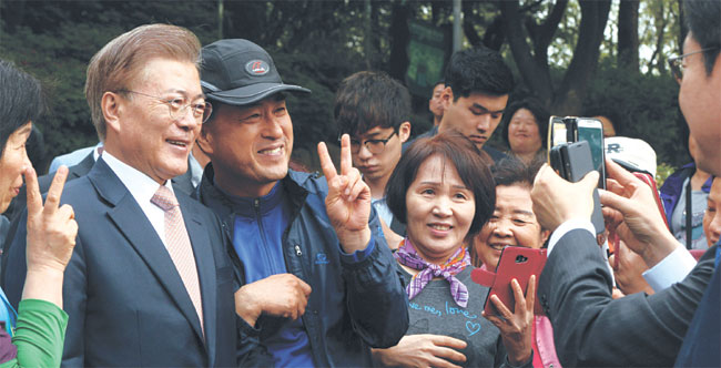 문재인 대통령이 11일 오전 첫 청와대 출근을 위해 서울 서대문구 홍은동 자택을 나서다 주민들과 인사를 나누며 기념사진을 찍고 있다.