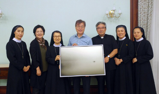 문재인 대통령과 김정숙 여사가 청와대 관저에 입주한 지난 13일 축복식을 주례한 유종만 홍제동성당 주임 신부와 수녀들과 기념 촬영을 하고 있다.