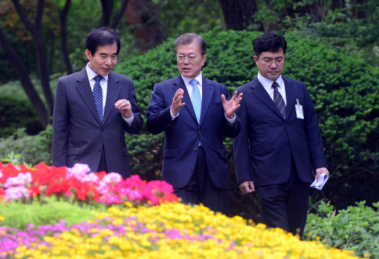 문재인 대통령이 15일 오전 주영훈(왼쪽) 경호실장, 송인배 전 더불어민주당 일정총괄팀장과 함께 청와대 관저에서 여민관 사무실로 걸어서 출근하고 있다. 문 대통령은 13일 홍은동 사저에서 청와대 관저로 거처를 옮겼다.  연합뉴스