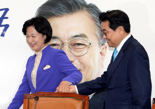 추미애(왼쪽) 더불어민주당 대표가 15일 오전 국회를 예방한 전병헌 청와대 정무수석비서관의 손을 잡고 회의실로 이동하고 있다.  김선규 기자 ufokim@