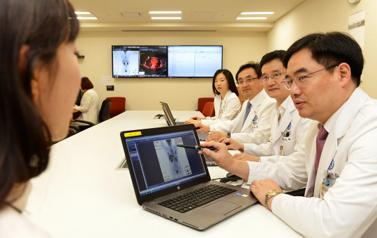 16일 연세암병원 유방암센터에서 김용배(오른쪽부터) 방사선종양학과 교수와 손주혁 종양내과 교수, 조영업 유방 외과 교수, 김현정 핵의학과 교수 등 의료진이 다학제 진료실에 모여 환자의 이야기를 들으며 치료 계획을 논의하고 있다.