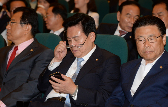 정우택(가운데) 자유한국당 대표 권한대행이 30일 오전 국회 도서관 대강당에서 열린 당 대선 평가 대토론회에서 안경을 벗고 휴대전화 문자 메시지를 확인하고 있다.