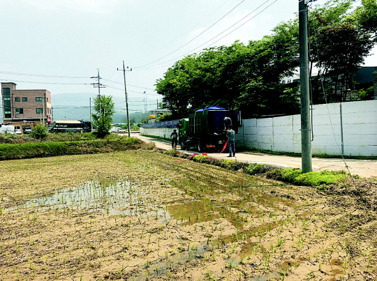 13일 경기 용인시 공무원들이 쓰레기 수거 차량에 물탱크를 싣고, 가뭄으로 갈라진 논에 농업용수를 공급하고 있다.  용인시제공