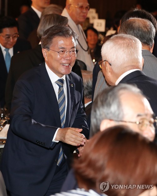 문재인 대통령이 15일 오후 6·15 남북정상회담 17주년 기념식이 열린 서울 여의도 63빌딩 컨벤션센터에서 참석자들과 악수하고 있다.