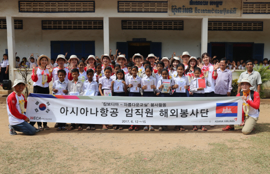 아시아나항공 캄보디아봉사단이 캄보디아 프놈펜의 썸라옹톰 초등학교에서 ‘아름다운 교실’ 행사를 마친 뒤 기념촬영을 하고 있다.