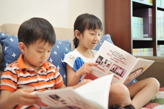 지윤(오른쪽), 시윤 남매가 21일 서울 송파구 잠실동 자택에서 사이좋게 책을 읽고 있다.   초록우산어린이재단 제공
