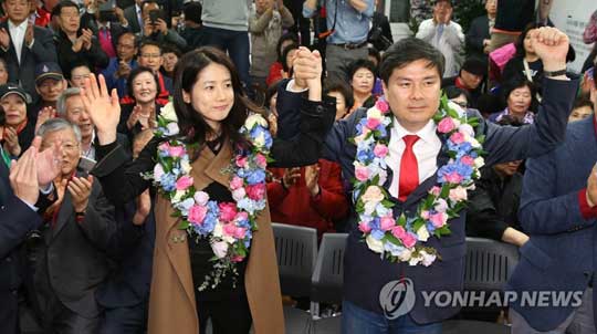 새누리당 서울 중구성동을 지상욱 당선인이 14일 새벽 서울 중구 신당동 선거사무소에서 당선이 확정된 뒤 부인인 배우 심은하씨와 함께 꽃다발을 목에 걸고 손을 들어 지지자들에게 답례하고 있다.