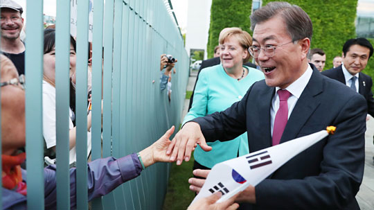 문재인 대통령과 앙겔라 메르켈 독일 총리가 5일 오후 한·독 정상만찬회담을 마치고 나오다 한국 교민을 만나 손을 잡아주고 있다.  연합뉴스