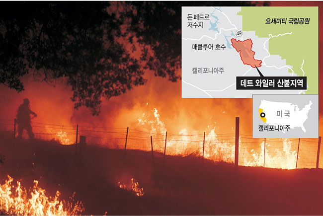 미국 캘리포니아주 소방관들이 18일 마리포사카운티에서 숲과 도로를 집어삼키면서 세계문화유산인 요세미티 국립공원으로 빠르게 번져가는 산불을 잡기 위해서 화염 속에서 화마와 사투를 벌이며 진화작업을 하고 있다.   AP연합뉴스