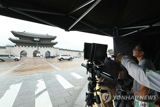 (서울=연합뉴스) 문화재청 직원과 관계자 등이 28일 서울 광화문에서 광화문 현판 색상 분석 연구를 위한 실물 크기 실험용 현판 촬영을 하고 있다.