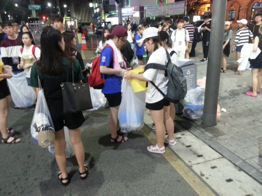 30일 서울 서대문구 연세로에서 ‘제5회 신촌물총축제’에 참가한 시민들이 분리수거하고 있다.