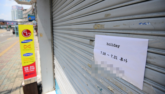 본격적인 휴가철을 맞은 30일 오후 서울 용산구 전자상가의 한 점포에 여름 휴가를 알리는 문구가 게시돼 있다.