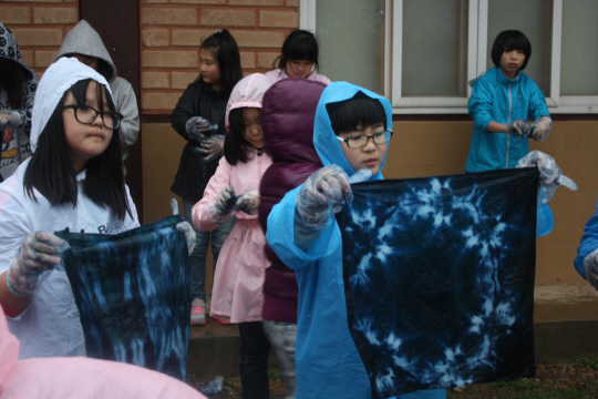 충남 청양군 대치면 가파마을을 방문해 천연염색 체험에 나선 어린이들이 자신이 직접 염료를 입힌 손수건을 들어보며 신기해하고 있다.  가파마을 제공