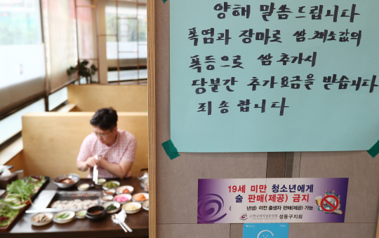 6일 서울의 한 쌈밥집 내부에 ‘불볕더위와 장마로 인해 쌈 채소를 추가 주문하면 요금을 받는다’는 안내문이 붙어 있다.