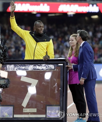 (런던 AP=연합뉴스) 서배스천 코(오른쪽) 국제육상경기연맹 회장이 14일(한국시간) 영국 런던 올림픽 스타디움에서 열린 우사인 볼트 은퇴식에서 런던 스타디움 트랙 조각을 선물하고 있다.