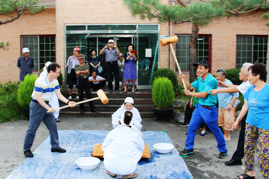 김원석(왼쪽) 농협경제지주 대표이사가 지난 2일 휴가를 맞아 명예이장으로 위촉받은 경기 양평군 지평면 망미마을에서 주민들과 함께 떡메치기를 하고 있다.  농협경제지주 제공