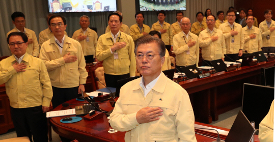 문재인 대통령과 국무위원들이 21일 오전 청와대 영상회의실에서 열린 을지국무회의에서 국기에 대한 경례를 하고 있다.